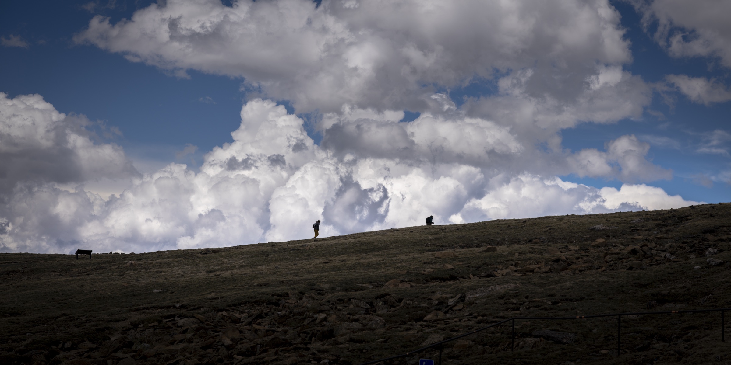 Two tiny figures on a high alpine overlook